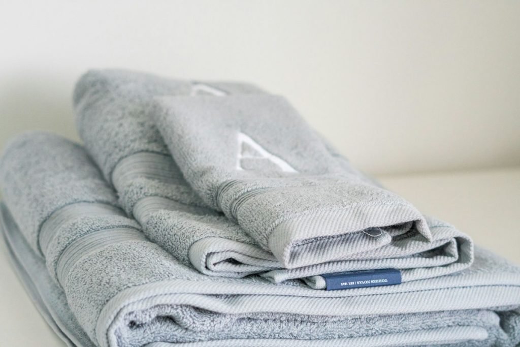 Folded grey towels stacked on a table